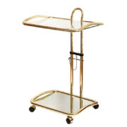W złotym kolorze mobilny stolik/wózek barowy na metalowej konstrukcji z giętych rurek z dwoma nakładanymi blatami, górny szklany z regulowaną wysokością, dolny lustrzany, Morex, Włochy, lata 70.